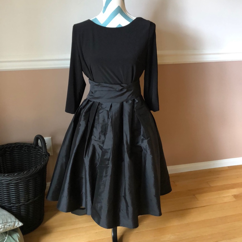 Black cocktail wrap dress with rhinestone accents on sleeves.